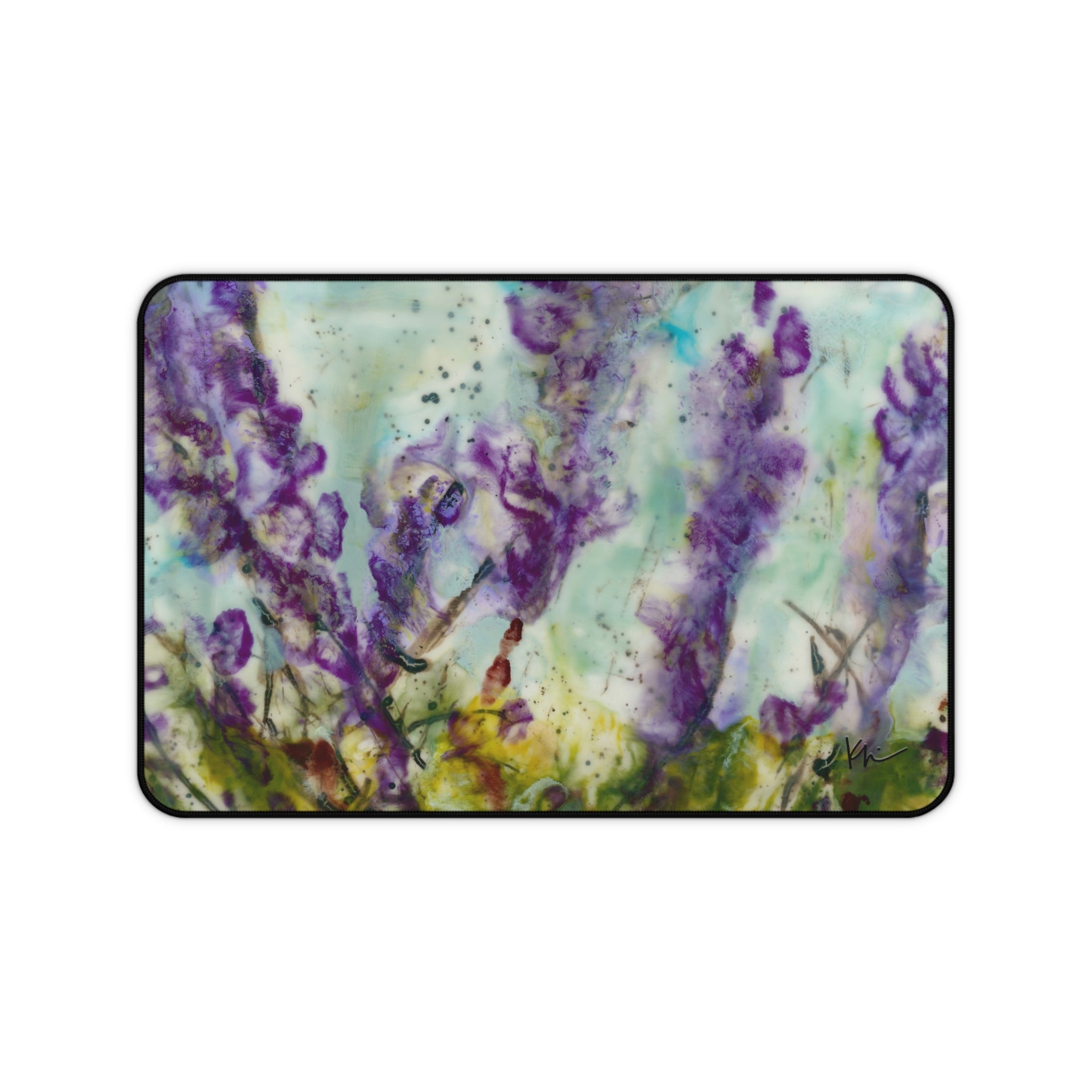 A desk mat featuring an abstract painting of purple wildflowers with a hemmed edge and anti-slip backing.