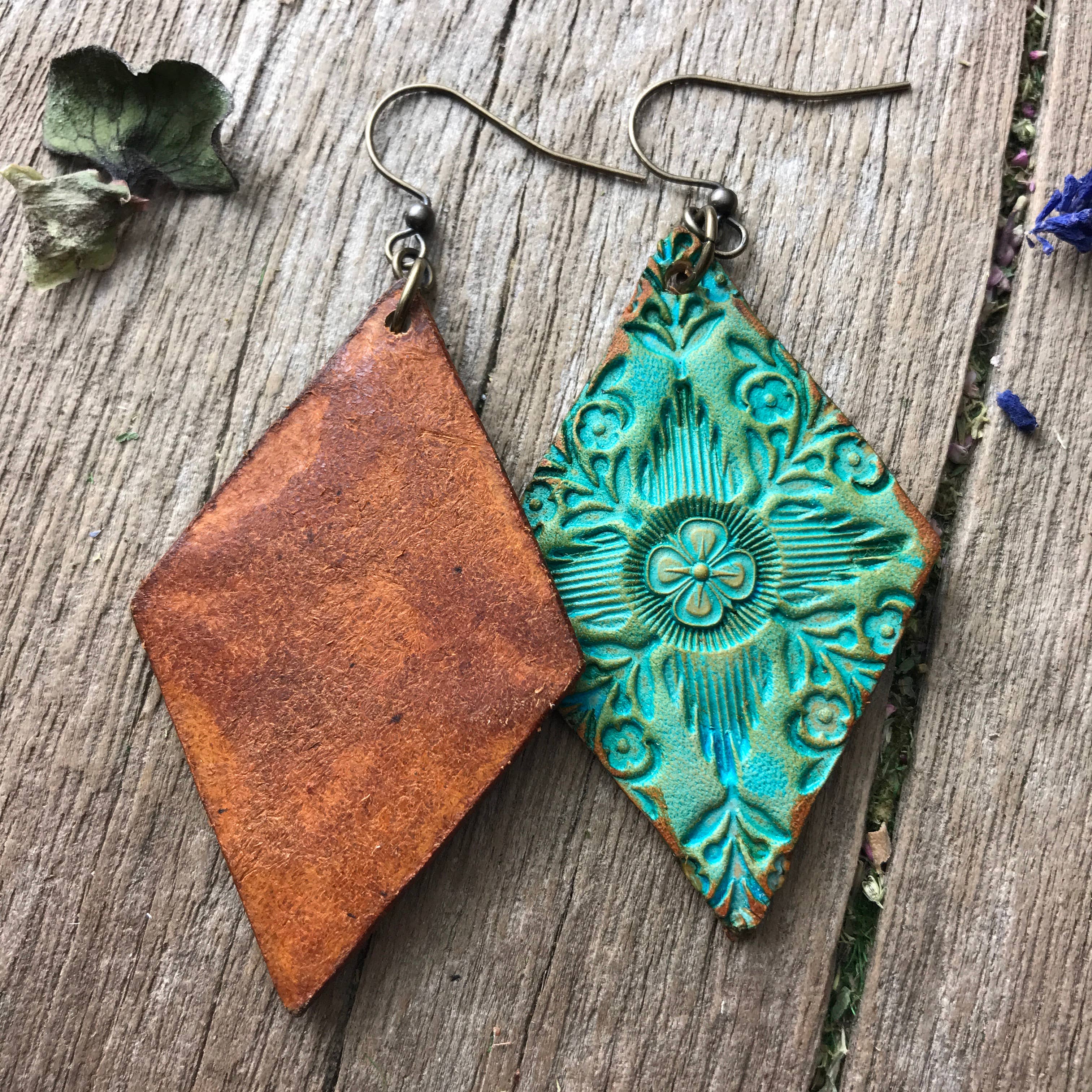 Front and back photo of hand crafted turquoise leather embossed earrings on a wooden surface.