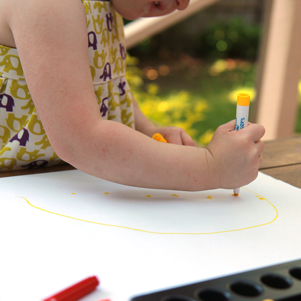 Photo of small child drawing with baby markers. Safe, washable felt pens for babies