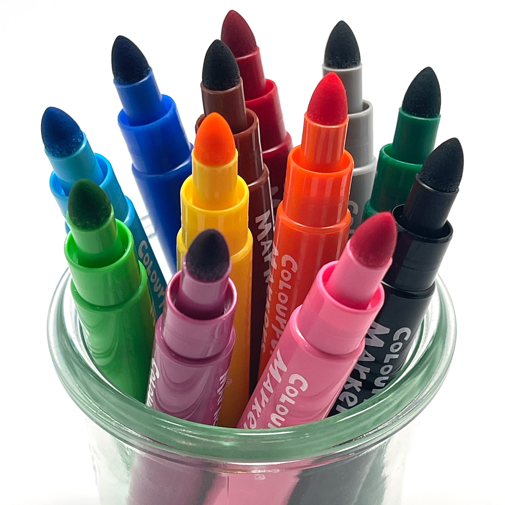A collection of felt pens in various colors with their caps on, placed in a clear glass container.