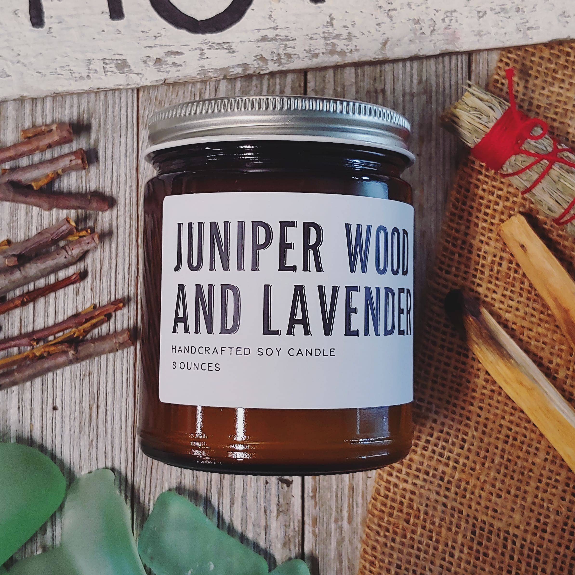 Jar of Juniper Wood and Lavender candle on a rustic wooden surface with natural elements.