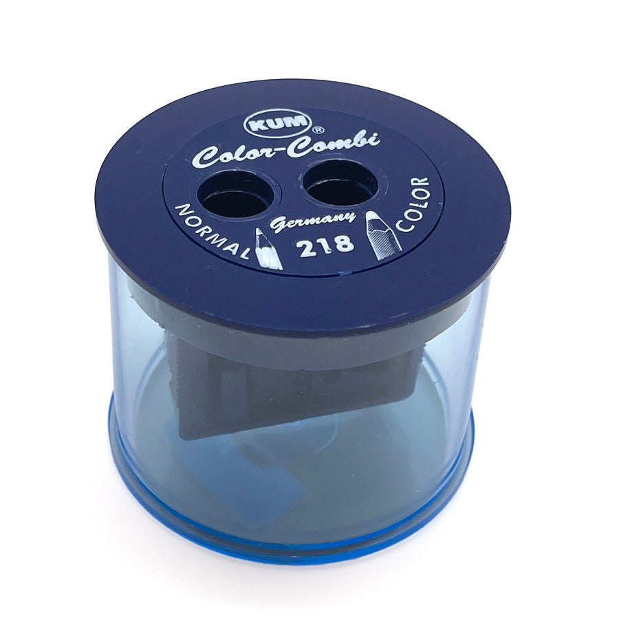 A KUM Color-Comb pencil sharpener in dark blue and translucent blue, shown on a clean white background.