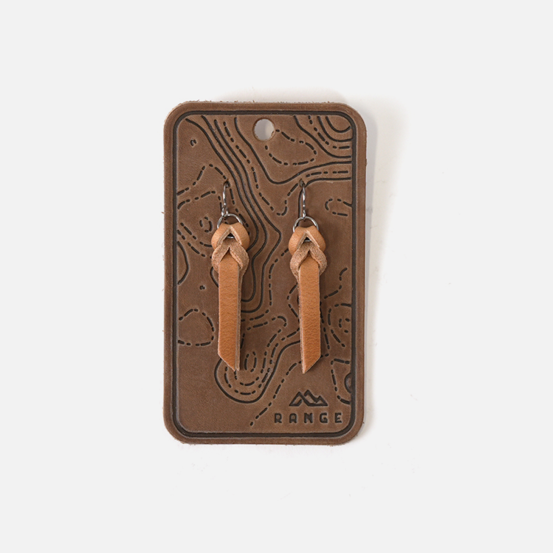 Pair of leather earrings on a branded card with a white background