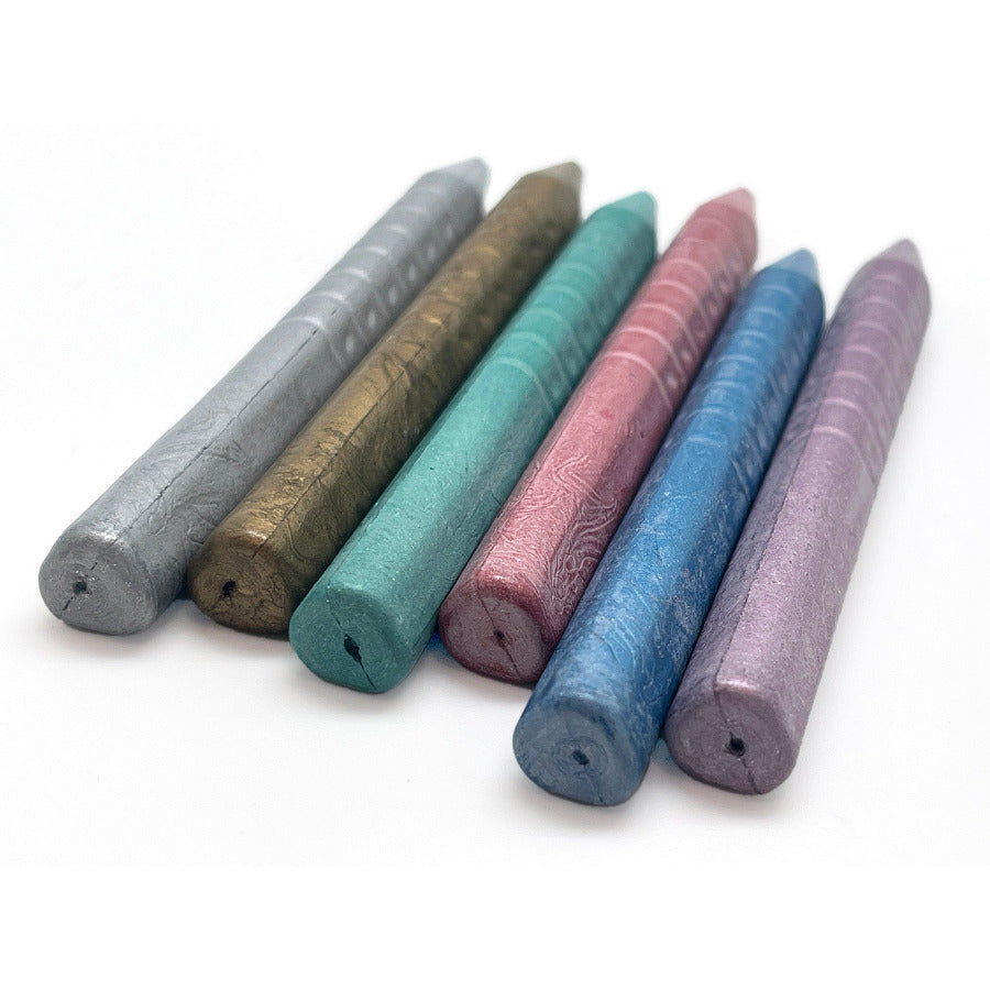 Set of 6 triangular shape metallic crayons on a white background