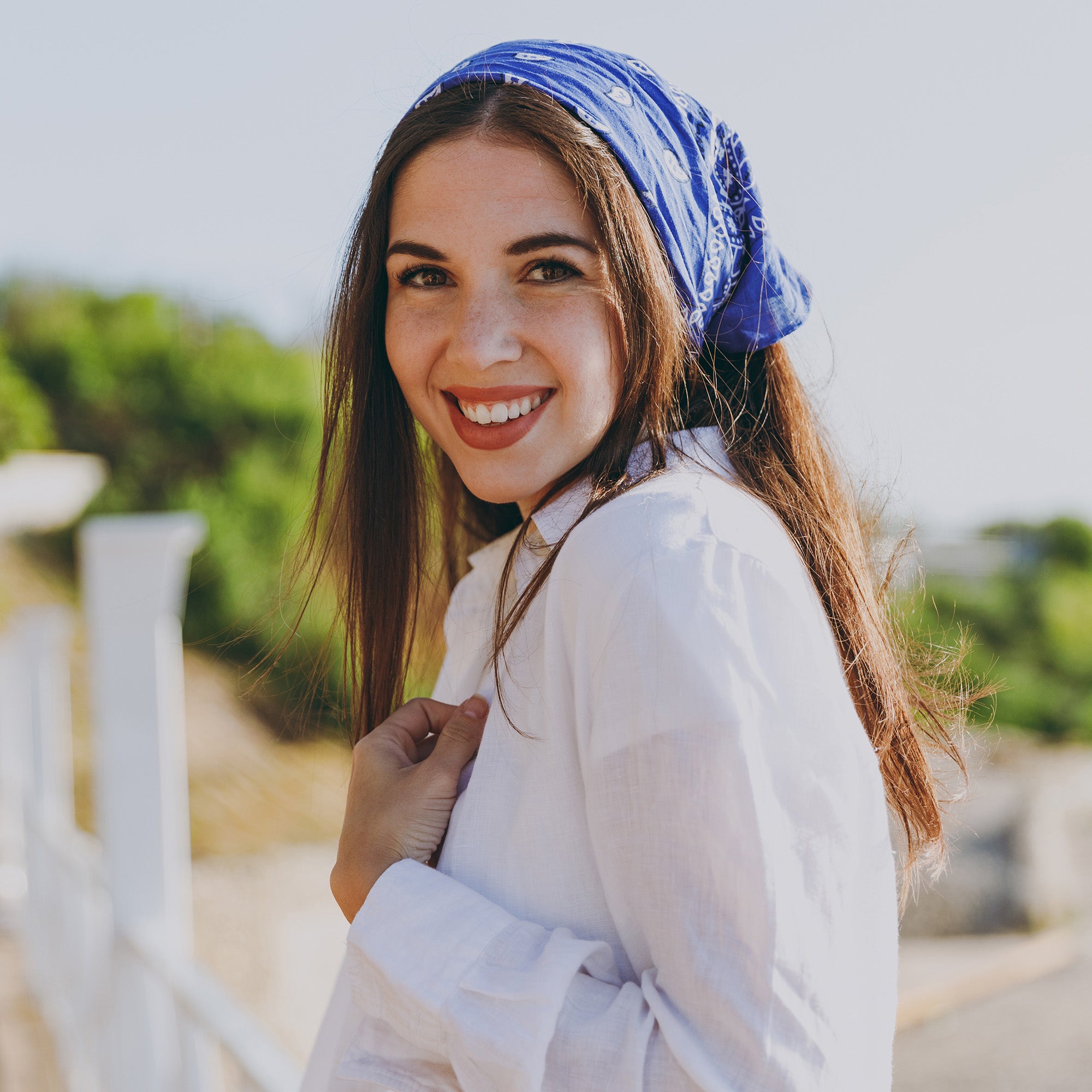 Woman wearing a blue Cotton paisley pattern bandana white shirt outdoors