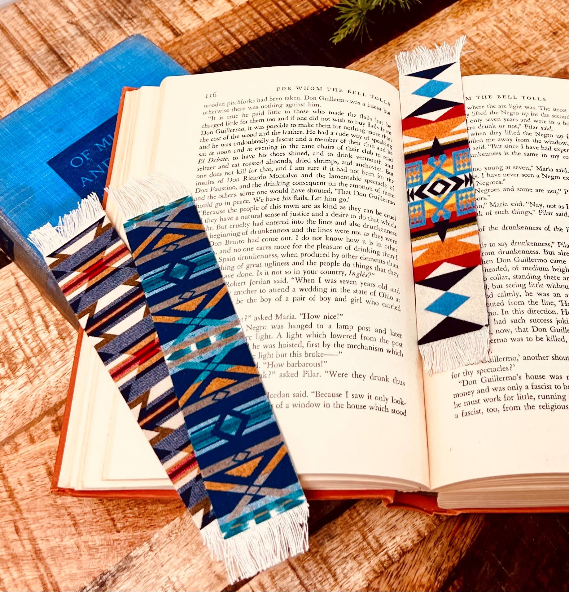 Open book with colorful patterned bookmarks on a wooden surface