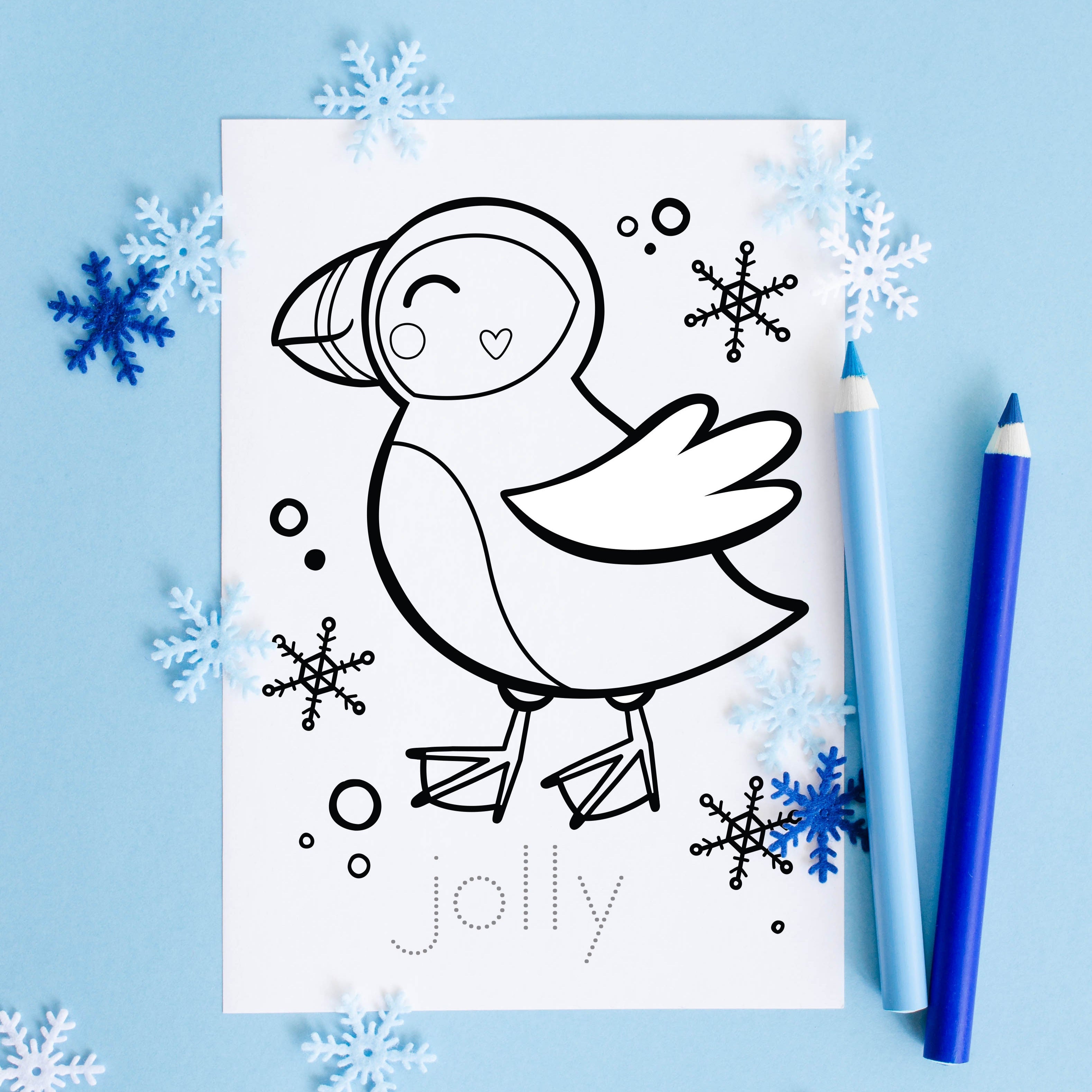 Christmas card to color with illustration of a puffin and the word 'jolly' on a blue background with snowflakes.