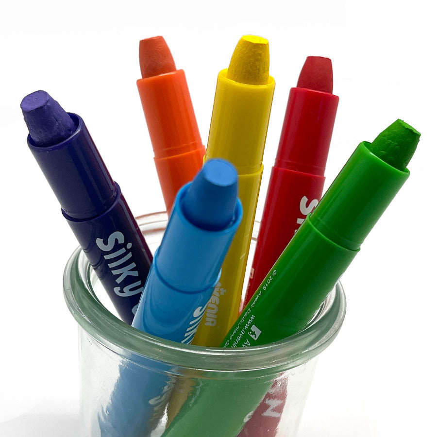 Twist up silky watercolor crayons in a glass jar against a white background