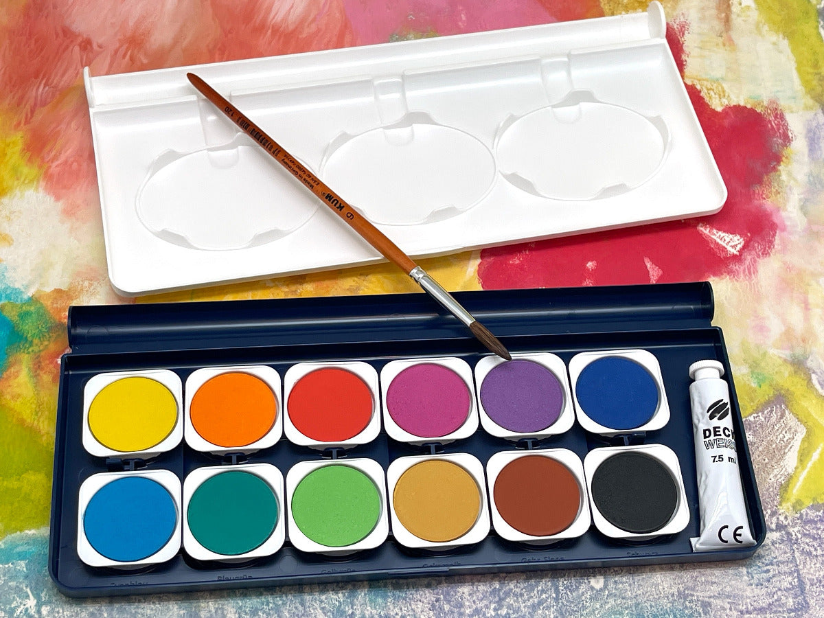 Watercolor paint set with brush and lid on a colorful background