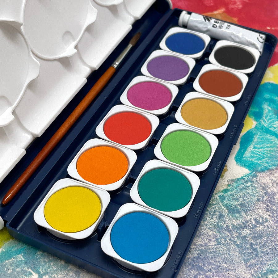 Close up of colorful watercolor paint pallet set with a paintbrush against a colorful background