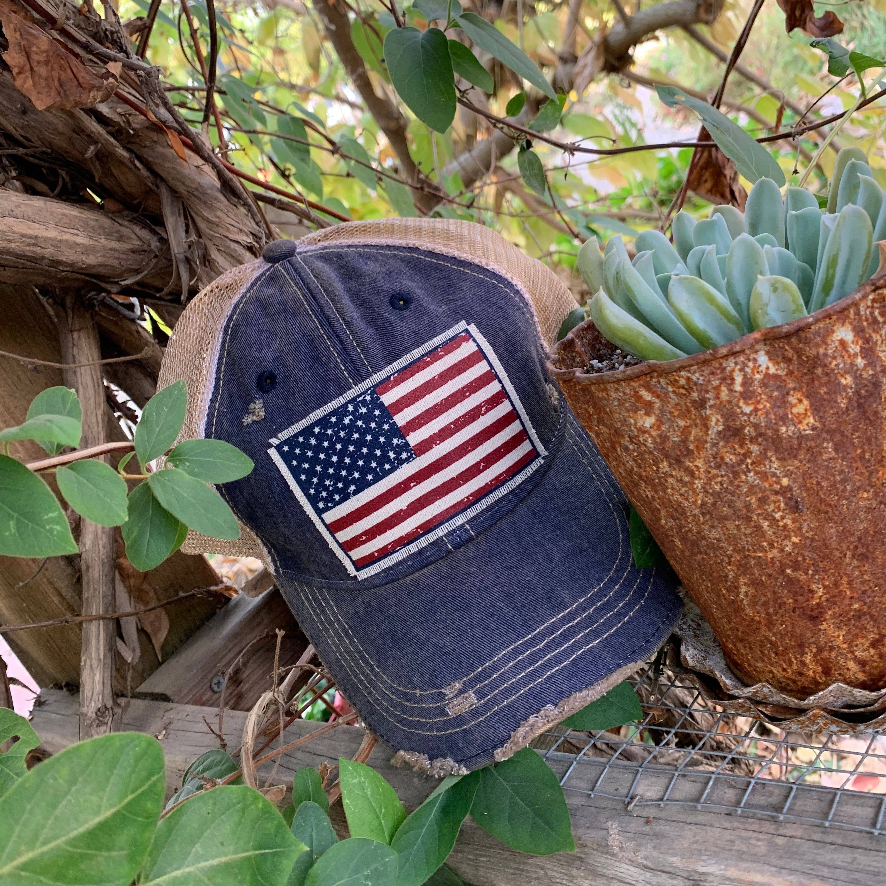 Blue cap with American flag patch on a natural background with plants