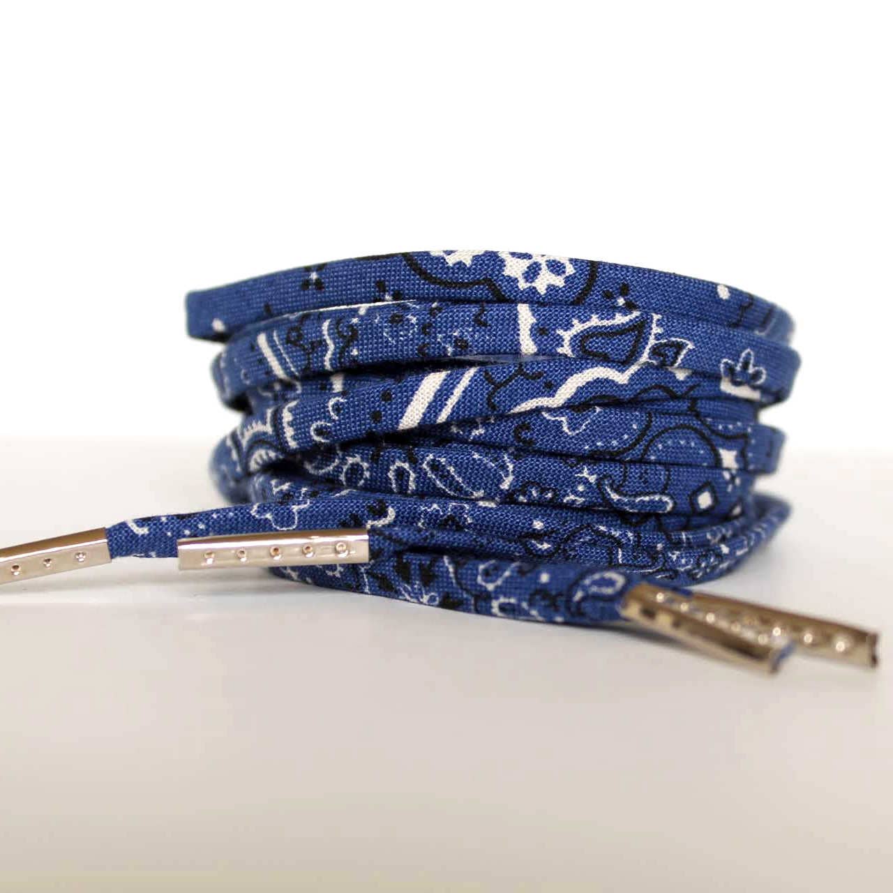 Blue patterned shoelaces with silver tips on a white background