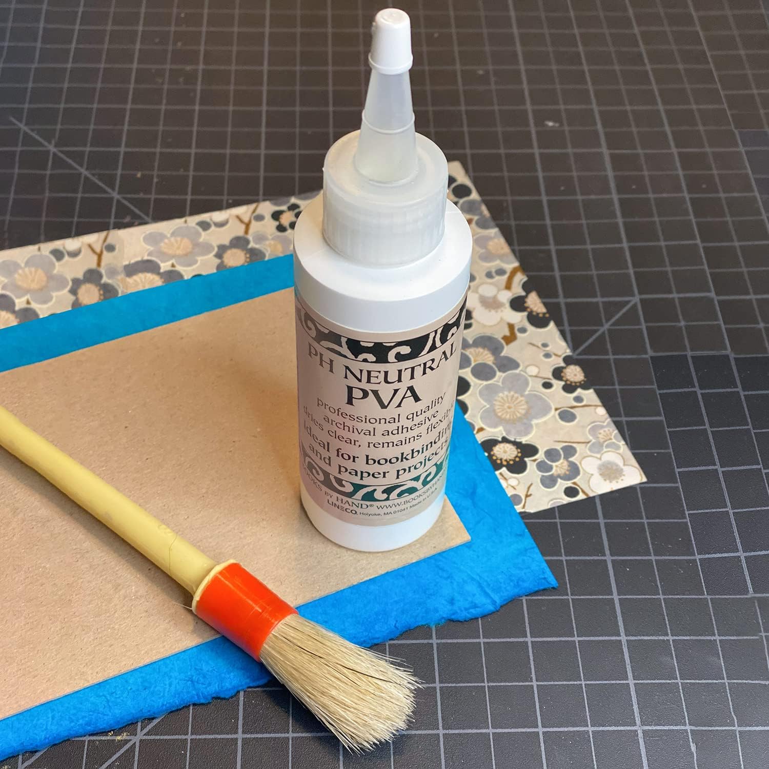 Bottle of PVA glue with brush and craft paper