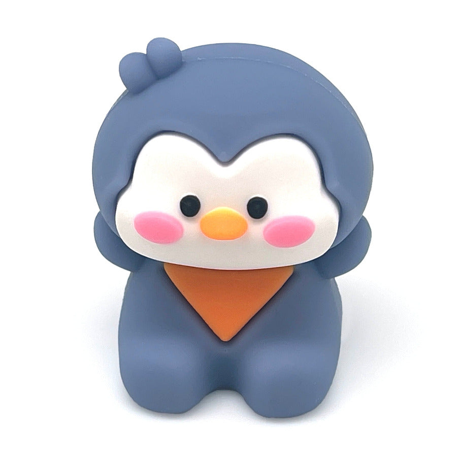 A cute, kawaii style penguin pencil sharpener in a purple color, wearing orange bandana, set against a plain white background.