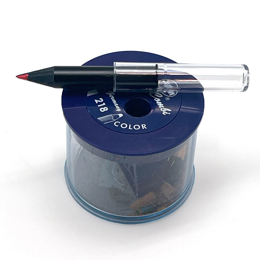 A very stubby black wood rainbow pencil with a clear plastic pencil extender sitting on top of a blue KUM color-combi pencil sharpener against a white background.