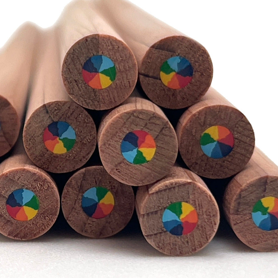 A close-up of several cedar wood pencils arranged in a stack, showing the circular multi-color rainbow swirl core on a white background.