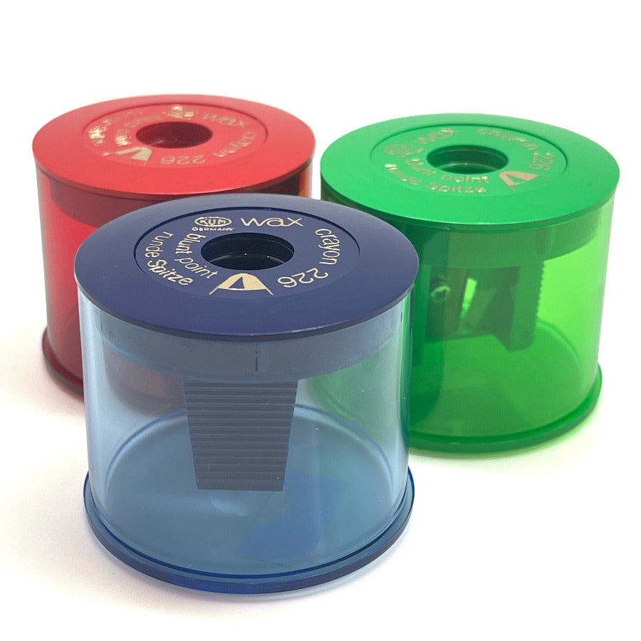 Three colorful KUM sharpeners for jumbo crayons or jumbo pencils (red, blue, green) on a white background