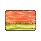 A desk mat with an abstract landscape painting featuring a vibrant sunset-like color palette.