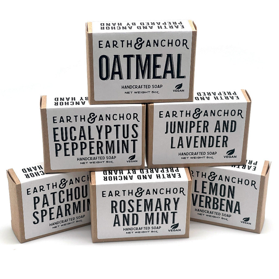 Stack of natural soaps in box packaging against white background