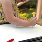 Photo of small child drawing with baby markers. Safe, washable felt pens for babies