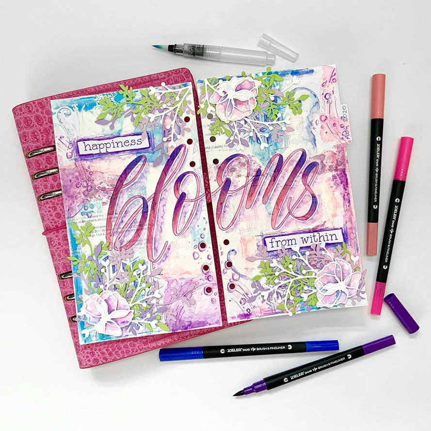 Floral-themed planners with colorful text and duo tip brush pens on a white background