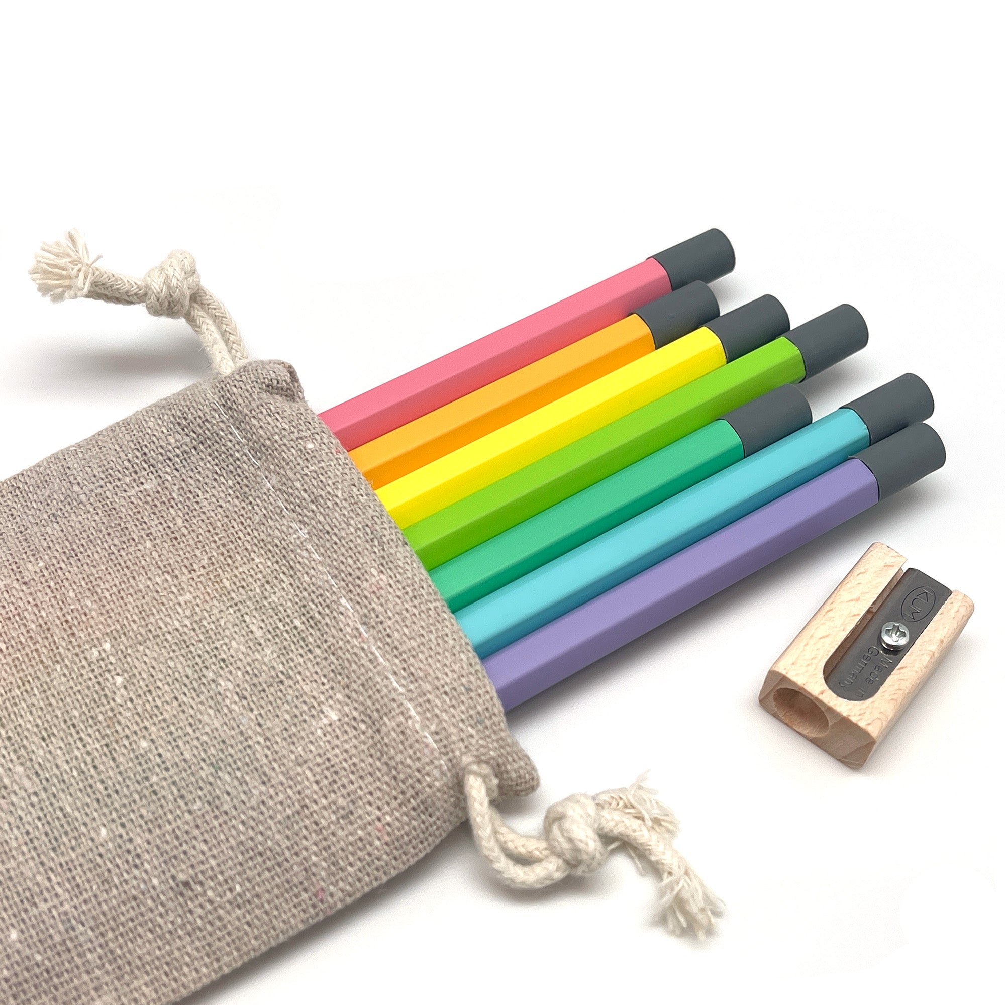 Set of colorful Camel HB Graphite pencils with a wooden sharpener and linen storage pouch on a white background