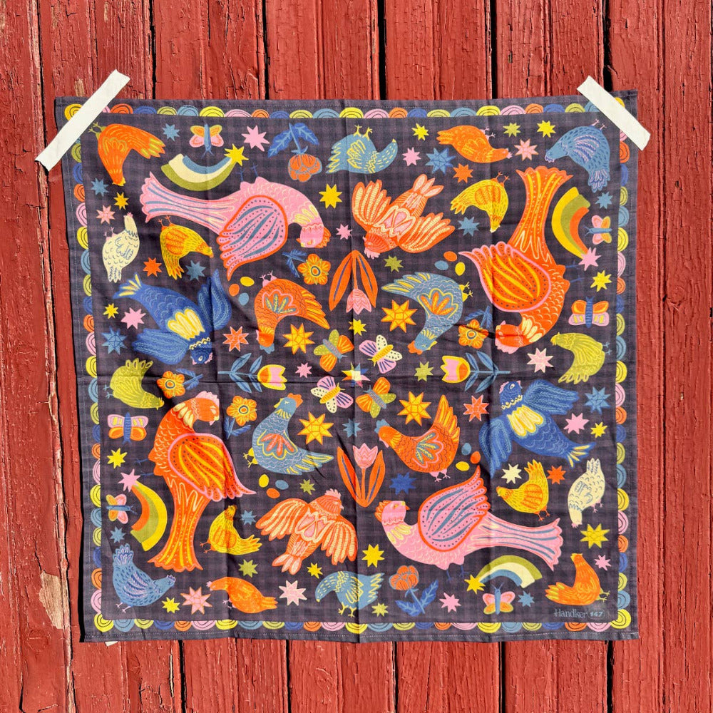 Colorful patterned cotton scarf bandana with birds and flowers on a wooden background