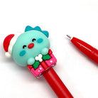 Red gel pen with a turquoise dinosaur head wearing a Santa hat pen cap on a white background