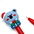 Red gel pen with a blue koala bear wearing Santa hat  pen cap on a white background