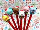 Set of six gel pens with Kawaii style animals wearing Christmas hats and sitting on gift boxes on the pen lid with a colorful snowflake background.