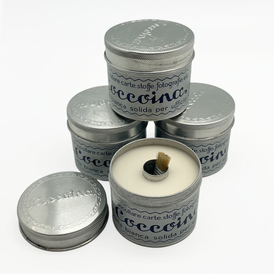 Paste in tin containers stacked against a white background