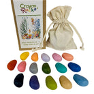 Crayon Rocks packaging with colorful pebble shape crayons and a drawstring bag on a white background