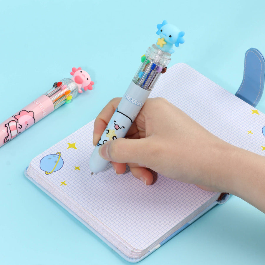 Hand holding a multi-color retractable  pen with axolotl character on a light blue background