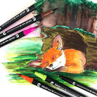 Duo tip brush markers and fine liner pens with a drawing of a fox in a forest