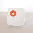 White eraser with an orange grip space on a light gray background