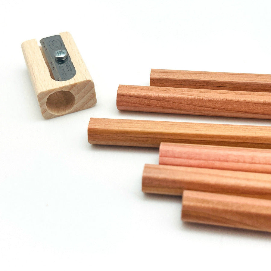 Set of eco friendly pencils made from FSC certified cedar wood with a pencil sharpener on a white background