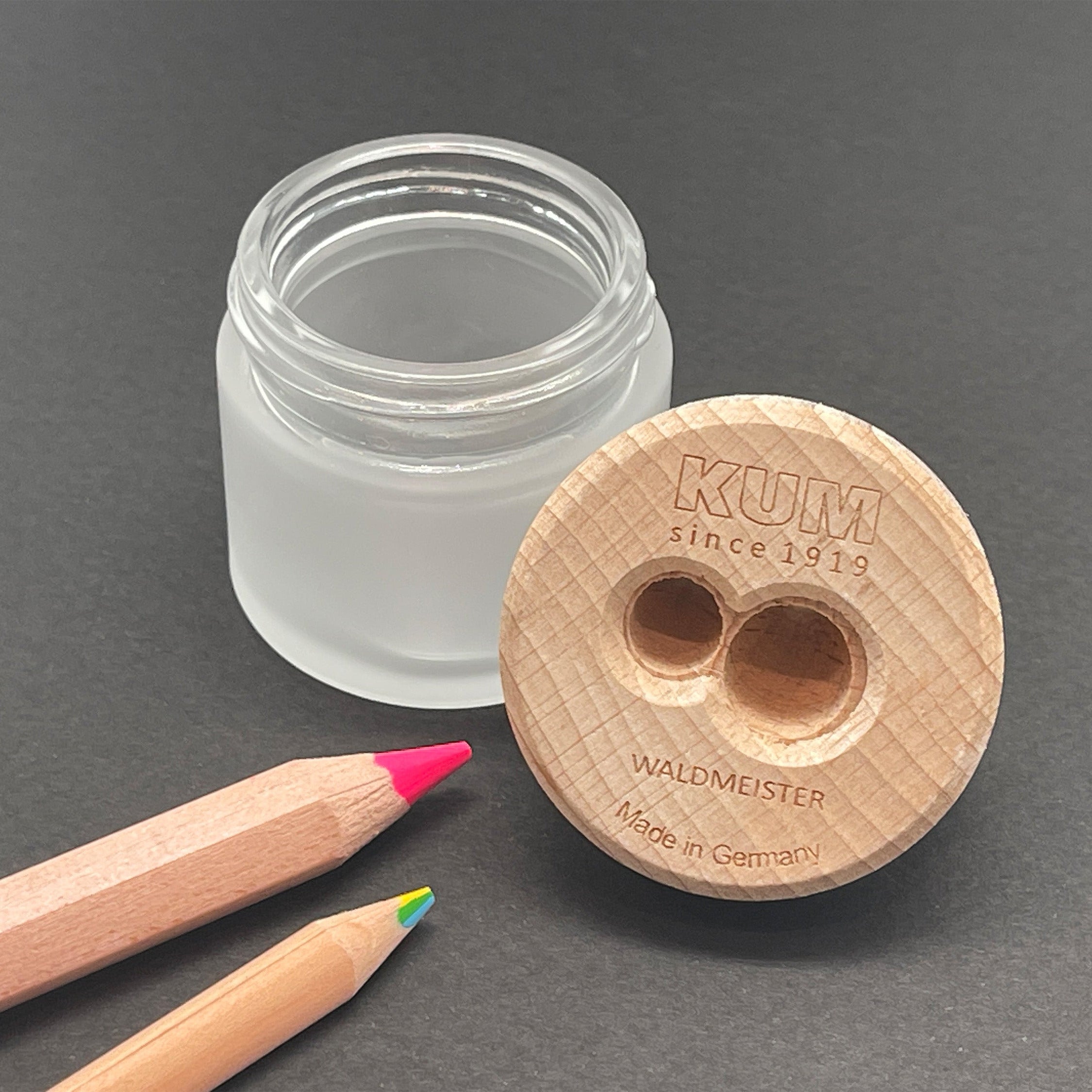 Wooden pencil sharpener with glass container on a gray background