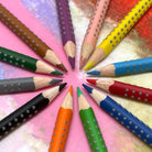 A set of grip watercolor pencils arranged in a circle in various colors, each featuring a unique ergonomic triangular design with soft dots for grip on a colorful background.