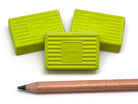 Three green Kum erasers on a white background with a wooden pencil.