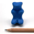 Blue gummy bear-shaped eraser with built in pencil sharpener next to a wooden pencil on a white background