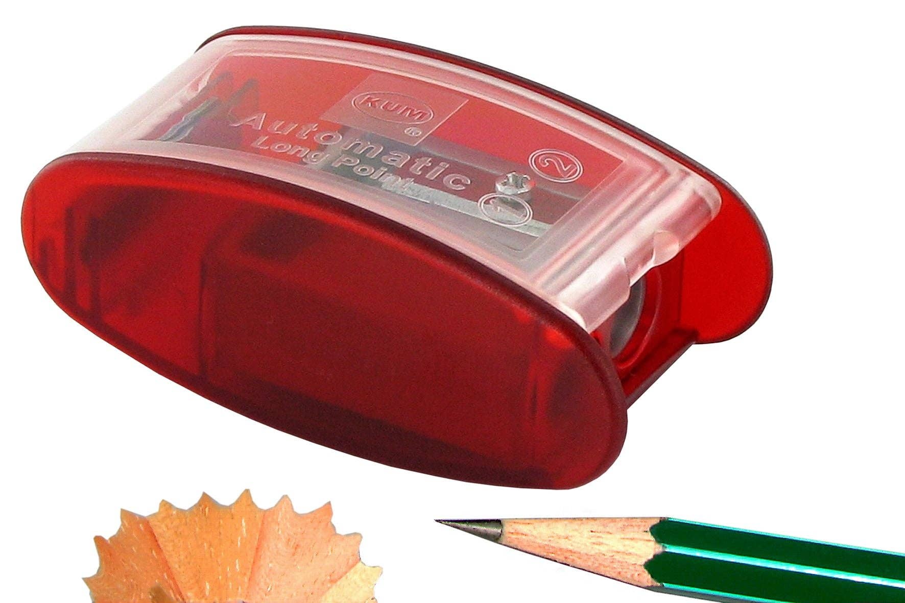 Red pencil sharpener with a pencil and pencil shavings on a white background