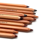A close-up, diagonal arrangement of Lyra Color Giants colored pencils in various skin tones, including brown, beige, and muted red, on a clean white background.