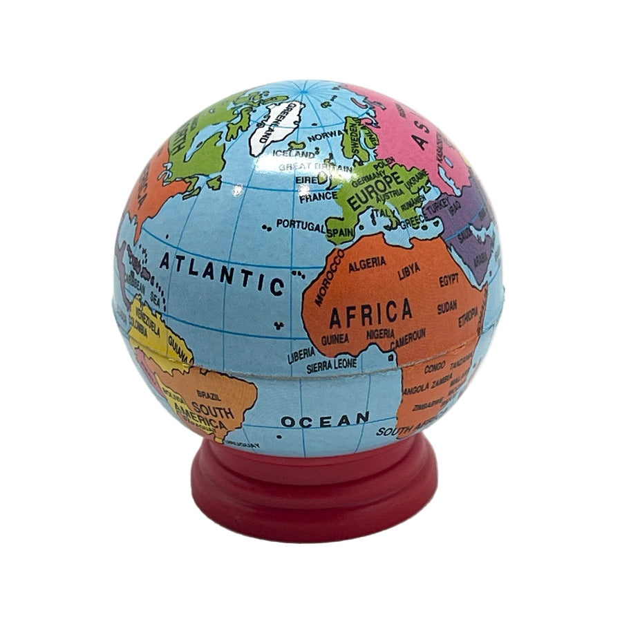 A colorful globe pencil sharpener with red base, showing the continents of Africa and Europe prominently, photographed on a white background.