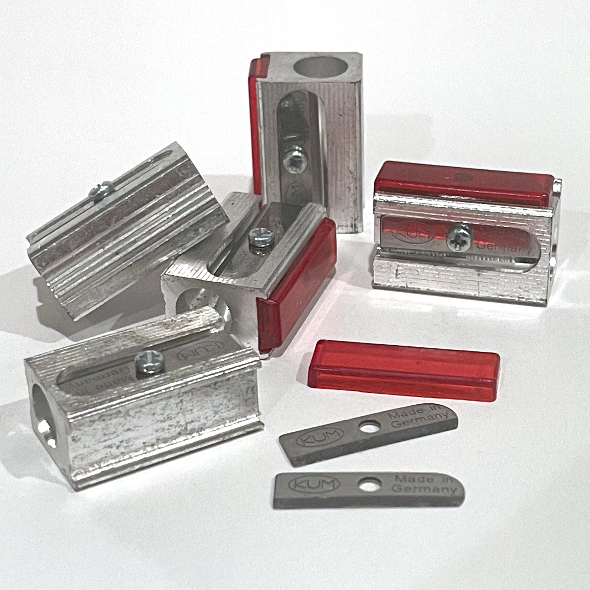 Metal Magnesium alloy pencil sharpeners with extra blades on a white background.