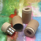 Cardboard canister pencil sharpeners with wooden tops on a colorful textured background