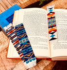 Open book with colorful patterned bookmarks on a wooden surface