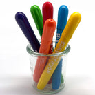 Silky watercolor crayons in a glass jar on a white background