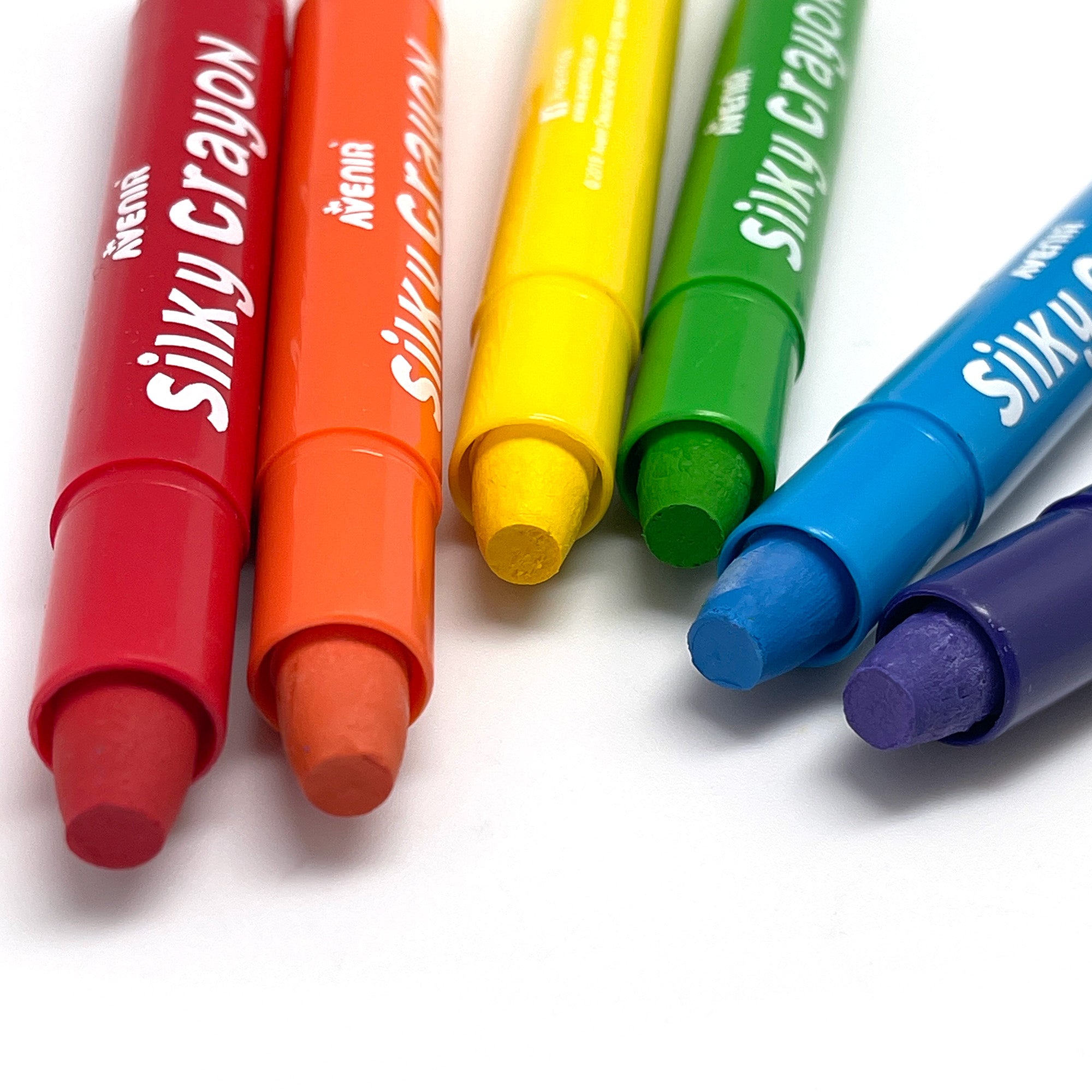 A set of six colorful silky crayons placed next to each other on a white surface.