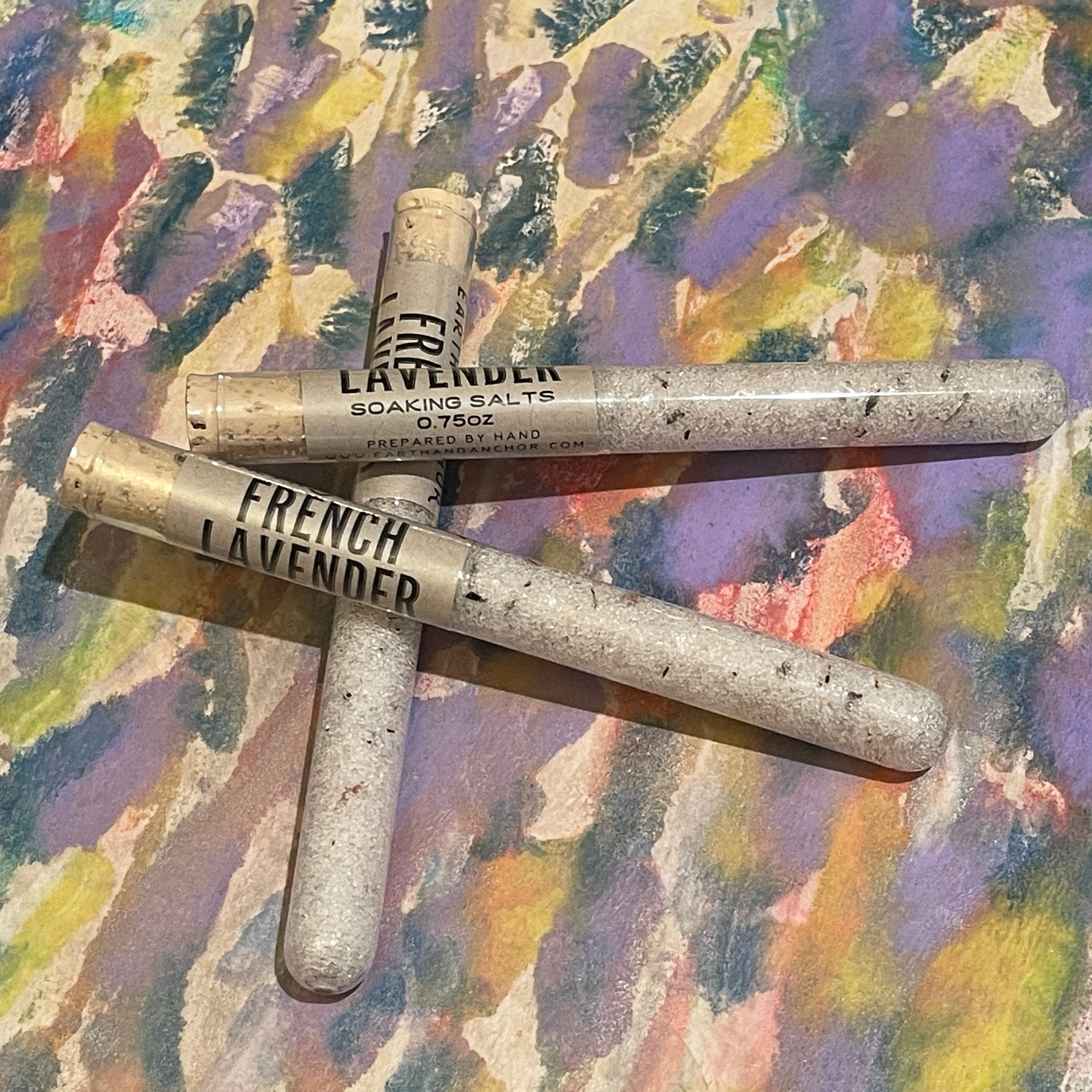 Three tubes of soaking salts French lavender scent on a colorful textured surface
