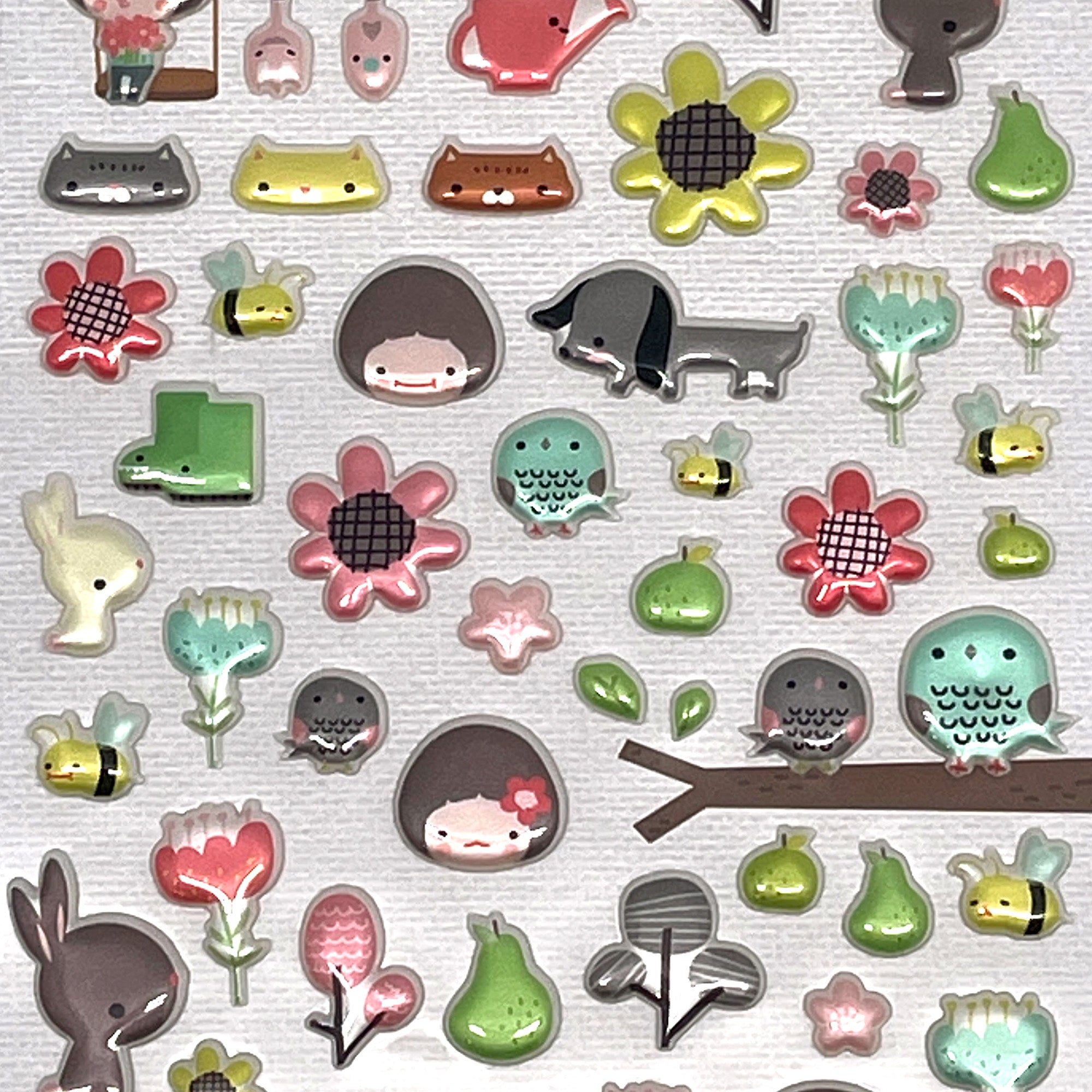 A sheet of various cute garden-themed stickers, including flowers, animals, and other decorative elements.